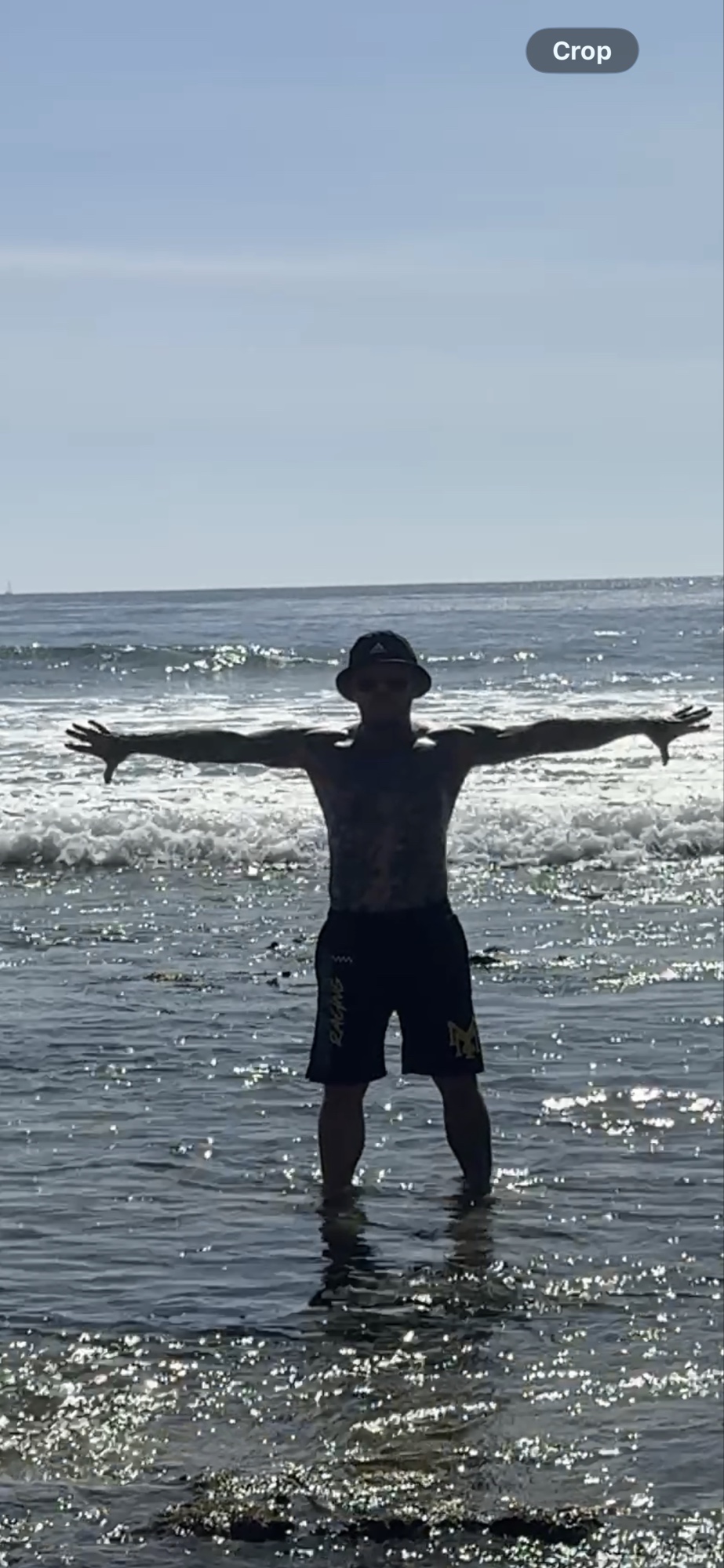 Shaun Anderson silhouetted practicing Korean breathwork at Laguna Beach, arms outstretched
